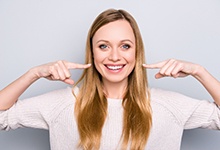 Woman pointing to a healthy smile.