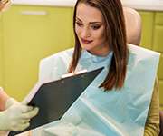 woman doing paperwork with dentist