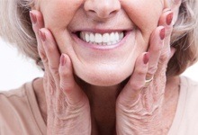 elderly woman smiling with implant dentures in West Palm Beach 