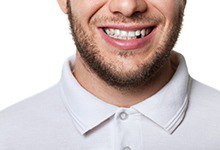 smiling man with a missing bottom tooth 